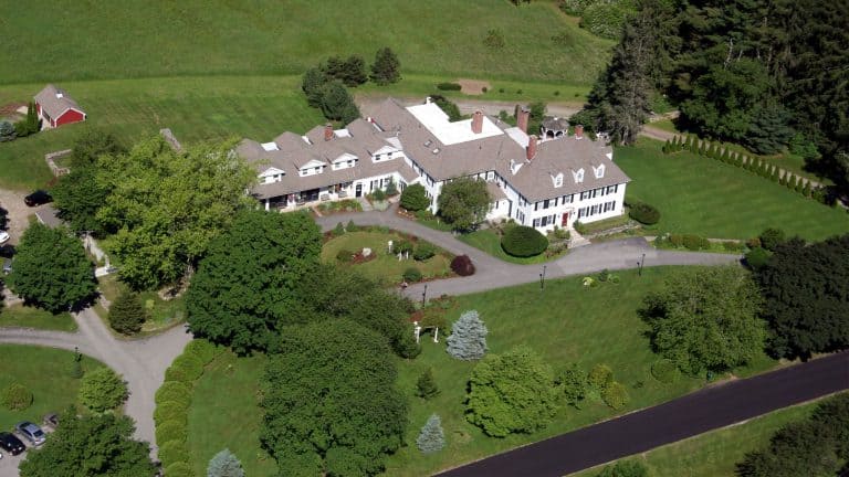 An aerial view of the Inn. The inn, painted white with black shutters, and the extensive manicured grounds.