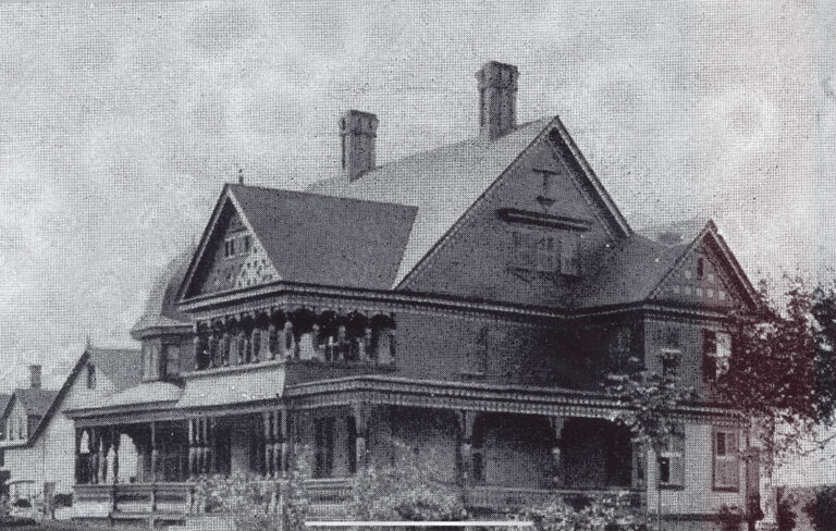Black and white photo of the Bowen Residence from 1885. 3 stories with chimneys and walk around porch